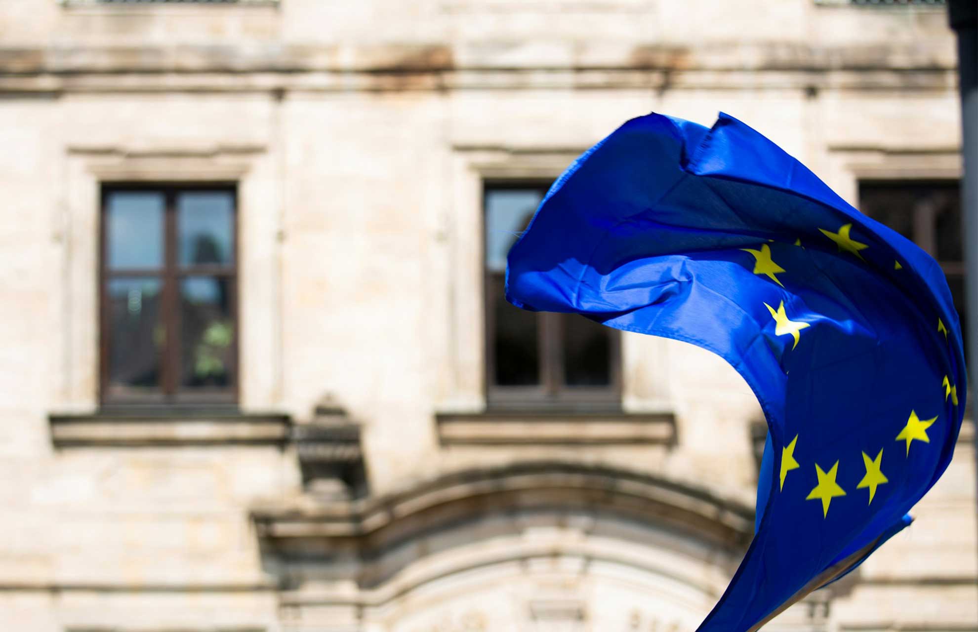 European Union flag and financial regulation documents representing the fragmented state of beneficial ownership register access across EU member states in 2026 following the AMLD6 implementation